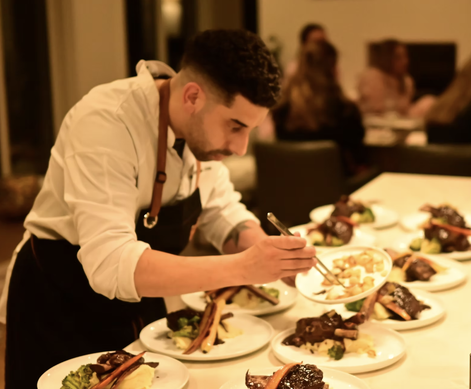 Chef Matthew plating dishes tableside for guests